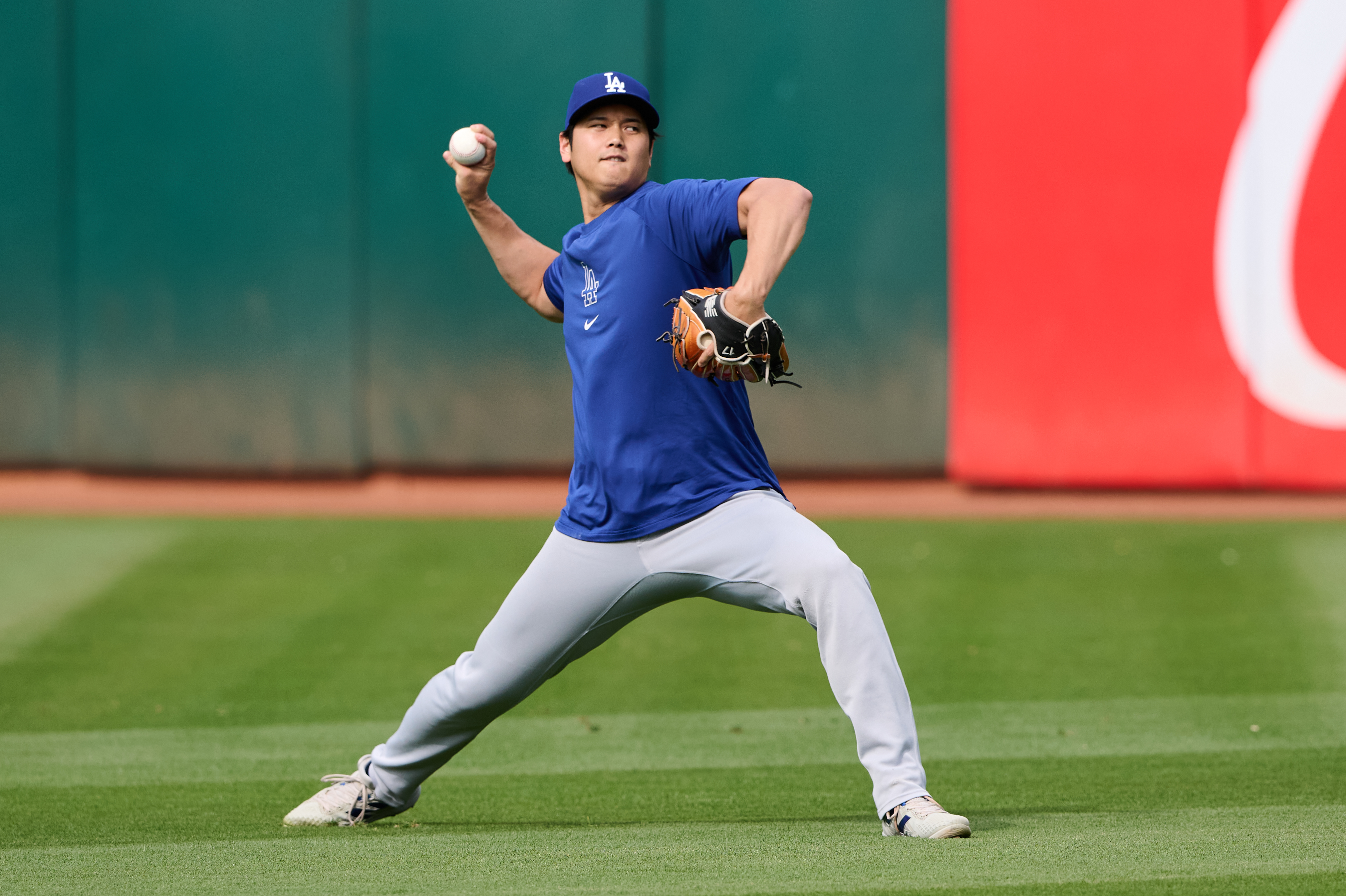 Aug 2, 2024; Oakland, California, USA; Los Angeles Dodgers designated hitter Shohei Ohtani (17) throws the ball in the outfield during warmups before the game between the Los Angeles Dodgers and the Oakland Athletics at Oakland-Alameda County Coliseum. Mandatory Credit: Robert Edwards-Imagn Images