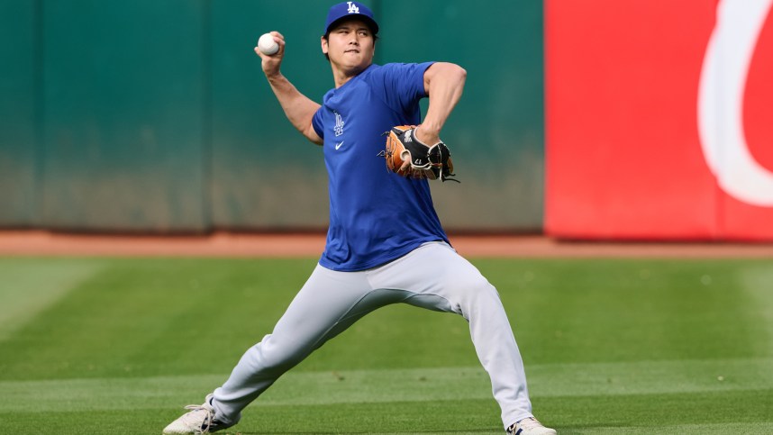 Aug 2, 2024; Oakland, California, USA; Los Angeles Dodgers designated hitter Shohei Ohtani (17) throws the ball in the outfield during warmups before the game between the Los Angeles Dodgers and the Oakland Athletics at Oakland-Alameda County Coliseum. Mandatory Credit: Robert Edwards-Imagn Images