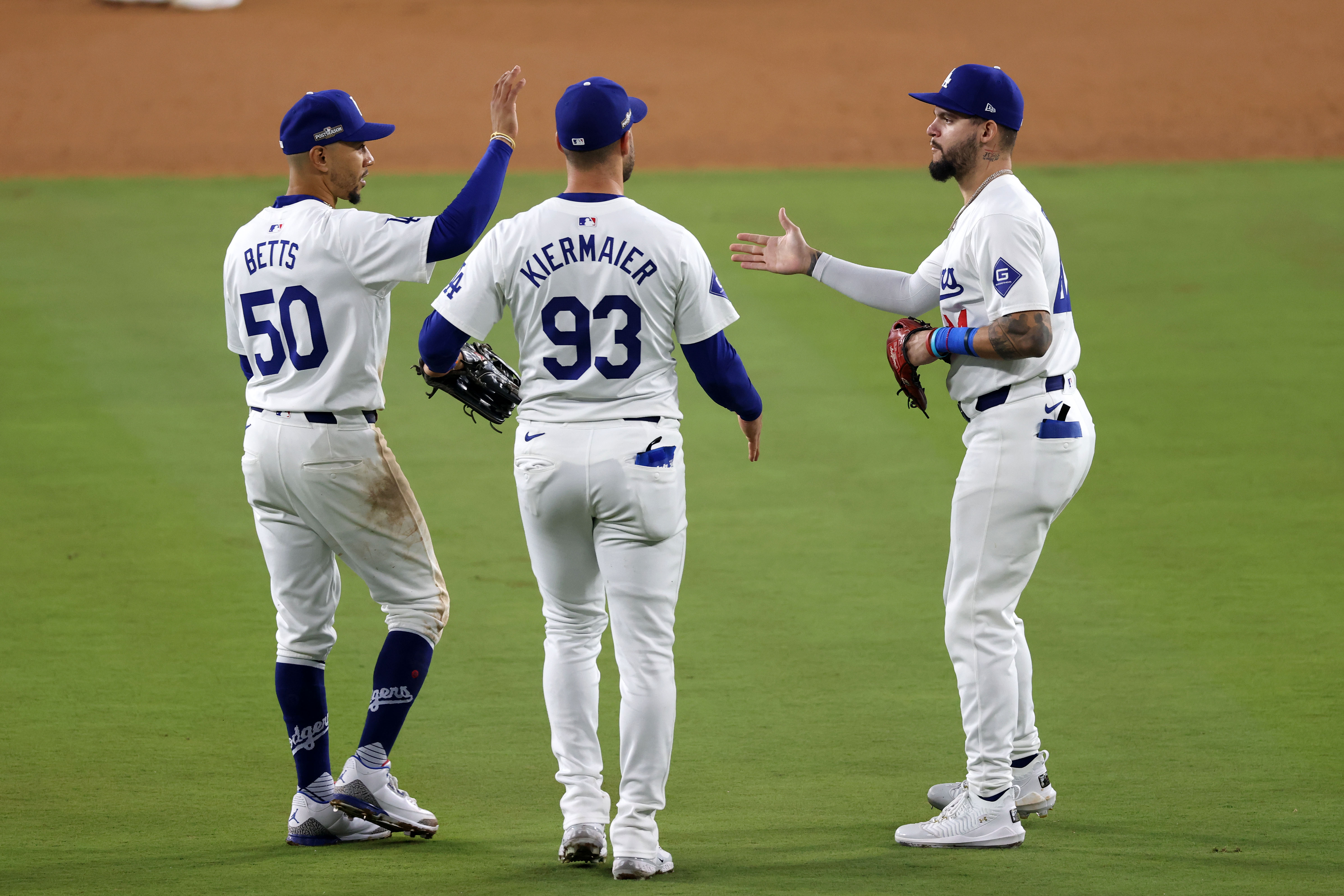 Oct 13, 2024; Los Angeles, California, USA; Los Angeles Dodgers shortstop Mookie Betts (50) reacts with outfielder Andy Pages (44) and outfielder Kevin Kiermaier (93)  teammates after the ninth inning during game one of the NLCS for the 2024 MLB Playoffs at Dodger Stadium.  Mandatory Credit: Jason Parkhurst-Imagn Images