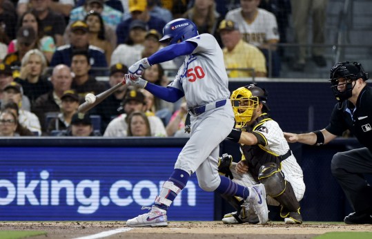 Oct 9, 2024; San Diego, California, USA; Los Angeles Dodgers shortstop Mookie Betts (50) hits a RBI single in the second inning against the San Diego Padres during game four of the NLDS for the 2024 MLB Playoffs at Petco Park. Mandatory Credit: David Frerker-Imagn Images