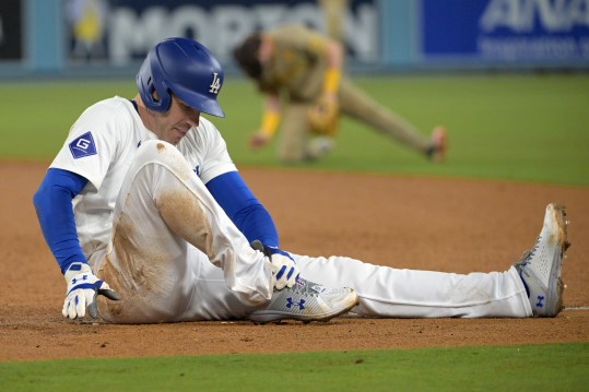 Sep 26, 2024; Los Angeles, California, USA;  Los Angeles Dodgers first baseman Freddie Freeman (5) grabs his ankle after he was injured during a play at first base in the seventh inning against the San Diego Padres at Dodger Stadium. Mandatory Credit: Jayne Kamin-Oncea-Imagn Images