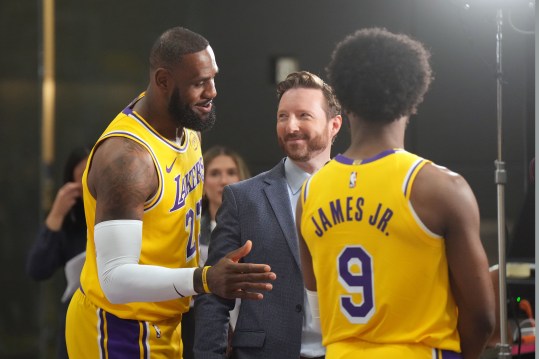 Sep 30, 2024; El Segundo, CA, USA; Los Angeles Lakers forward LeBron James (23) watches as ESPN reporter Dave McMenamin, (center) interviews son Bronny James (9) during media day at the UCLA Health Training Center. Mandatory Credit: Kirby Lee-Imagn Images