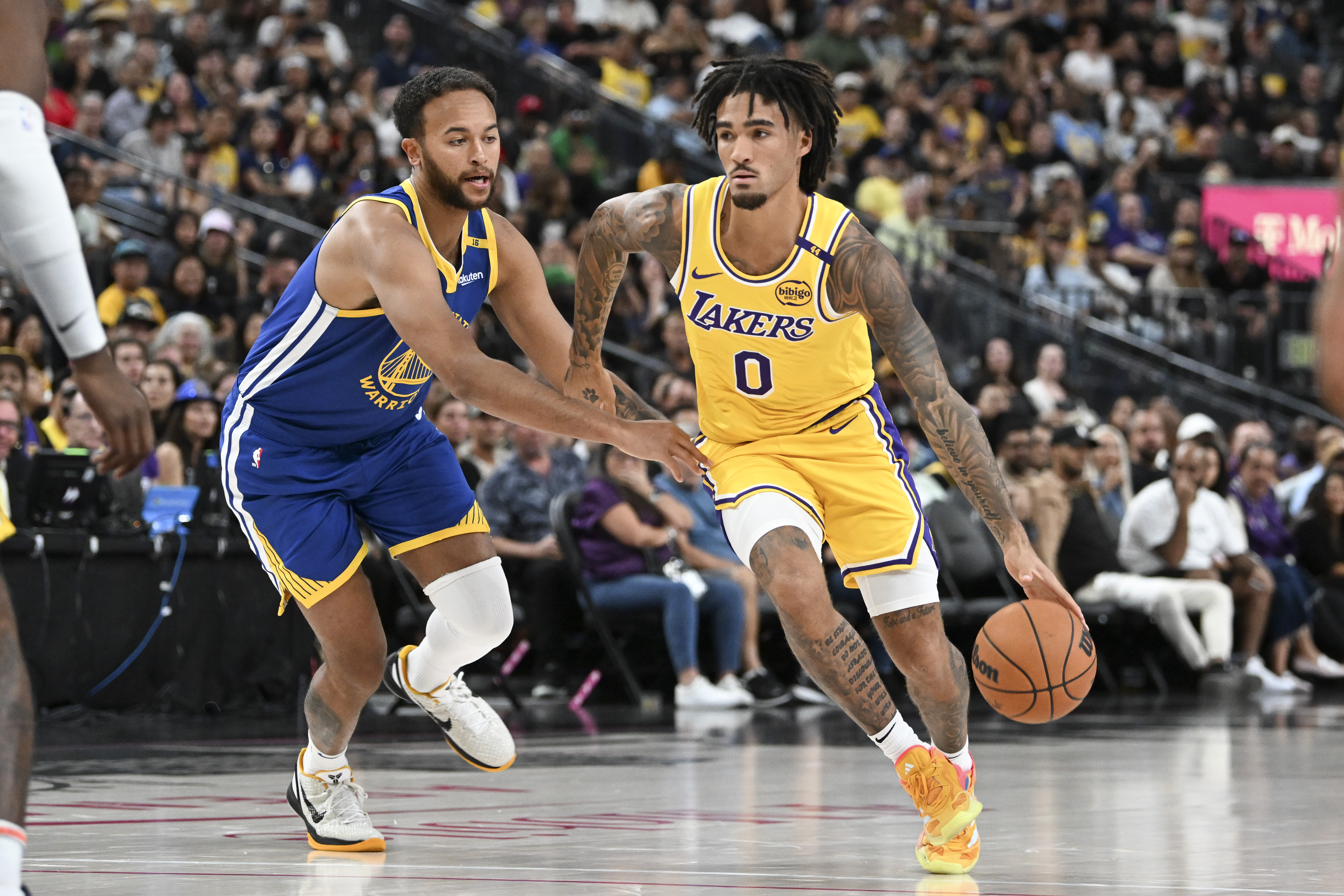 Oct 15, 2024; Las Vegas, Nevada, USA; Los Angeles Lakers guard Jalen Hood-Schifino (0) drives past Golden State Warriors forward Kyle Anderson (1) in the third quarter during a preseason game at T-Mobile Arena. Mandatory Credit: Candice Ward-Imagn Images