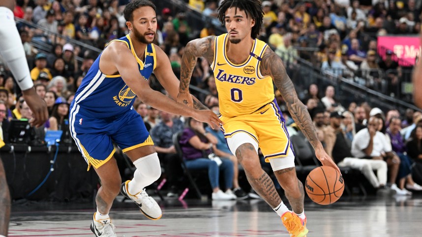 Oct 15, 2024; Las Vegas, Nevada, USA; Los Angeles Lakers guard Jalen Hood-Schifino (0) drives past Golden State Warriors forward Kyle Anderson (1) in the third quarter during a preseason game at T-Mobile Arena. Mandatory Credit: Candice Ward-Imagn Images