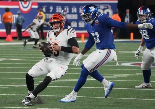 Oct 13, 2024; East Rutherford, New Jersey, USA;  Cincinnati Bengals quarterback Joe Burrow (9) is chased by New York Giants linebacker Azeez Ojulari (51) during the first half at MetLife Stadium. Mandatory Credit: Robert Deutsch-Imagn Images