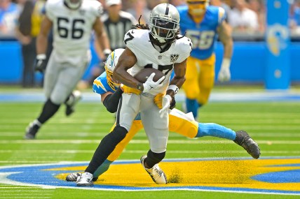 Sep 8, 2024; Inglewood, California, USA; Las Vegas Raiders wide receiver Davante Adams (17) is stopped by Los Angeles Chargers safety Alohi Gilman (32) after a compete pass in the first half at SoFi Stadium. Mandatory Credit: Jayne Kamin-Oncea-Imagn Images