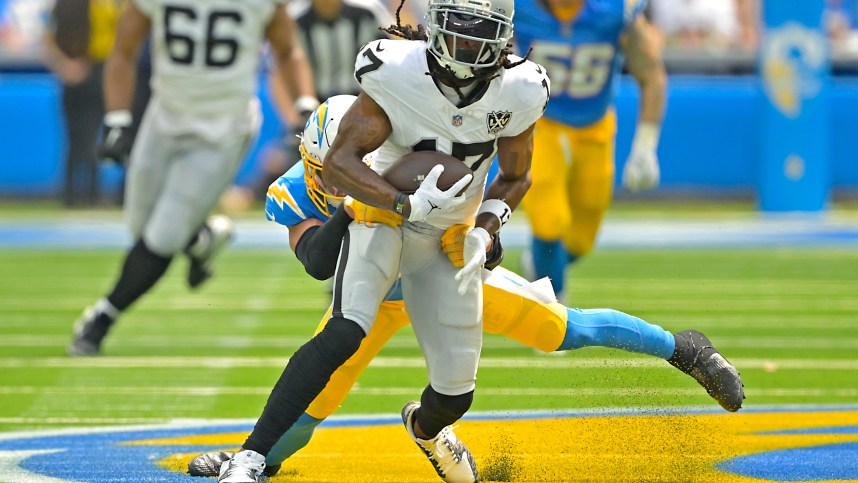 Sep 8, 2024; Inglewood, California, USA; Las Vegas Raiders wide receiver Davante Adams (17) is stopped by Los Angeles Chargers safety Alohi Gilman (32) after a compete pass in the first half at SoFi Stadium. Mandatory Credit: Jayne Kamin-Oncea-Imagn Images