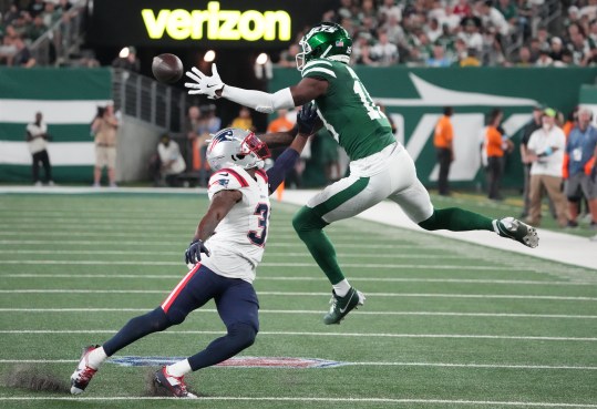 Sep 19, 2024; East Rutherford, New Jersey, USA;  New York Jets wide receiver Mike Williams (18) hauls in a 2nd half pass as New England Patriots cornerback Jonathan Jones (31)  defends at MetLife Stadium. Mandatory Credit: Robert Deutsch-Imagn Images