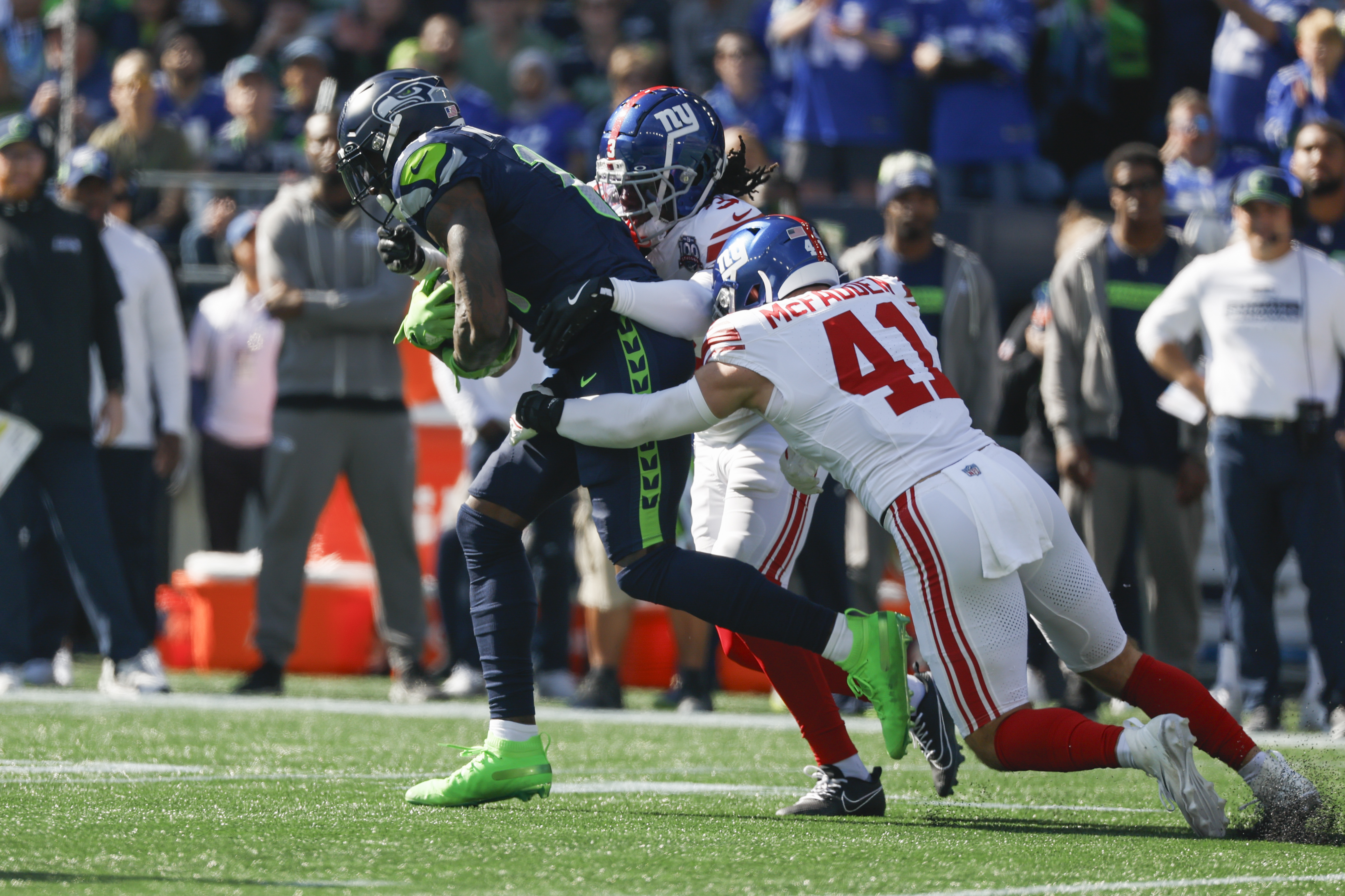 Oct 6, 2024; Seattle, Washington, USA; Seattle Seahawks wide receiver DK Metcalf (14) runs for yards after the catch against New York Giants cornerback Deonte Banks (3) and linebacker Micah McFadden (41) during the first quarter at Lumen Field. Mandatory Credit: Joe Nicholson-Imagn Images