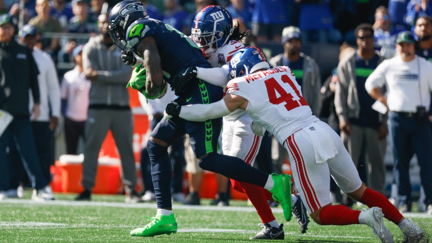 Oct 6, 2024; Seattle, Washington, USA; Seattle Seahawks wide receiver DK Metcalf (14) runs for yards after the catch against New York Giants cornerback Deonte Banks (3) and linebacker Micah McFadden (41) during the first quarter at Lumen Field. Mandatory Credit: Joe Nicholson-Imagn Images