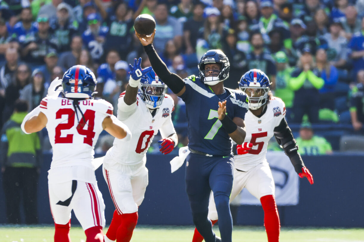 Oct 6, 2024; Seattle, Washington, USA; Seattle Seahawks quarterback Geno Smith (7) passes against New York Giants linebacker Brian Burns (0) and linebacker Kayvon Thibodeaux (5) during the second quarter at Lumen Field. Mandatory Credit: Joe Nicholson-Imagn Images