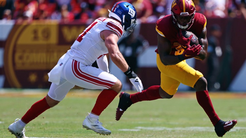 Sep 15, 2024; Landover, Maryland, USA; Washington Commanders running back Brian Robinson Jr. (8) runs the ball against New York Giants linebacker Micah McFadden (41) during the first quarter at Commanders Field. Mandatory Credit: Peter Casey-Imagn Images