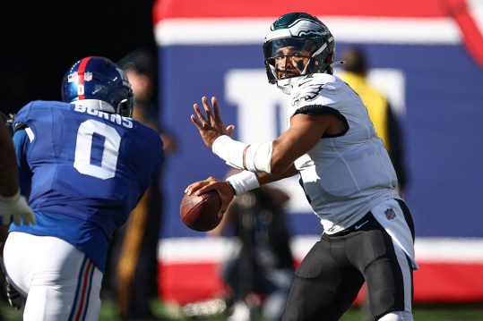 Oct 20, 2024; East Rutherford, New Jersey, USA; Philadelphia Eagles quarterback Jalen Hurts (1) throws the ball as New York Giants linebacker Brian Burns (0) pursues during the second half at MetLife Stadium. Mandatory Credit: Vincent Carchietta-Imagn Images