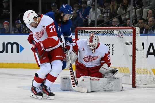 Oct 14, 2024; New York, New York, USA;  Detroit Red Wings center Dylan Larkin (71) blocks a shot in front of New York Rangers center Mika Zibanejad (93) and Detroit Red Wings goaltender Alex Lyon (34) during the first period at Madison Square Garden. Mandatory Credit: Dennis Schneidler-Imagn Images