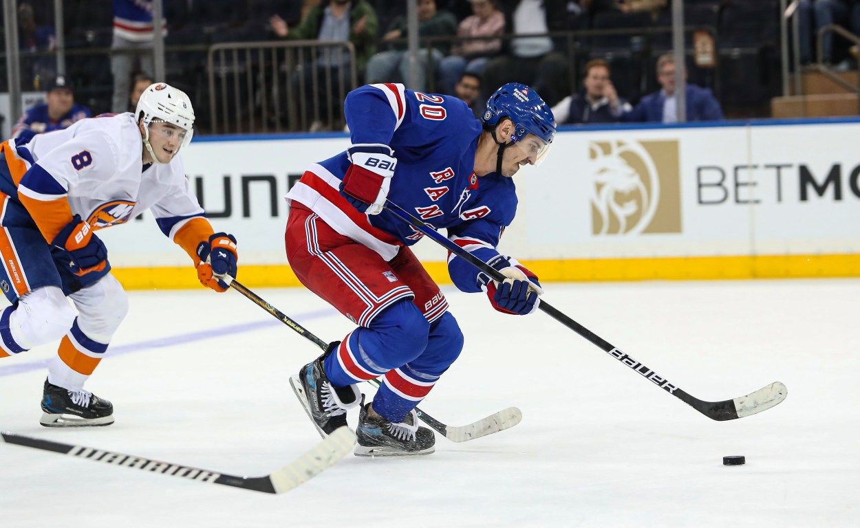 Sep 24, 2024; New York, New York, USA; New York Rangers left wing Chris Kreider (20) scores an empty-net goal while New York Islanders defenseman Noah Dobson (8) chases during the third period at Madison Square Garden. Mandatory Credit: Danny Wild-Imagn Images