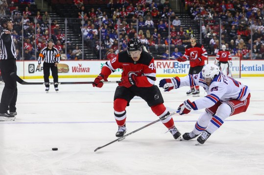 Sep 30, 2024; Newark, New Jersey, USA; New Jersey Devils left wing Brian Halonen (48) and New York Rangers defenseman Casey Fitzgerald (45) battle for the puck during the second period at Prudential Center. Mandatory Credit: Ed Mulholland-Imagn Images