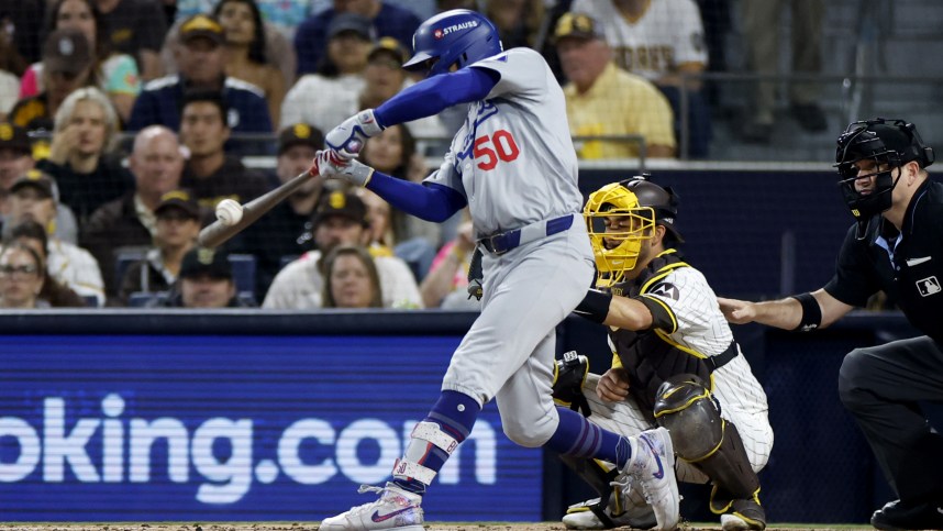 Oct 9, 2024; San Diego, California, USA; Los Angeles Dodgers shortstop Mookie Betts (50) hits a RBI single in the second inning against the San Diego Padres during game four of the NLDS for the 2024 MLB Playoffs at Petco Park. Mandatory Credit: David Frerker-Imagn Images