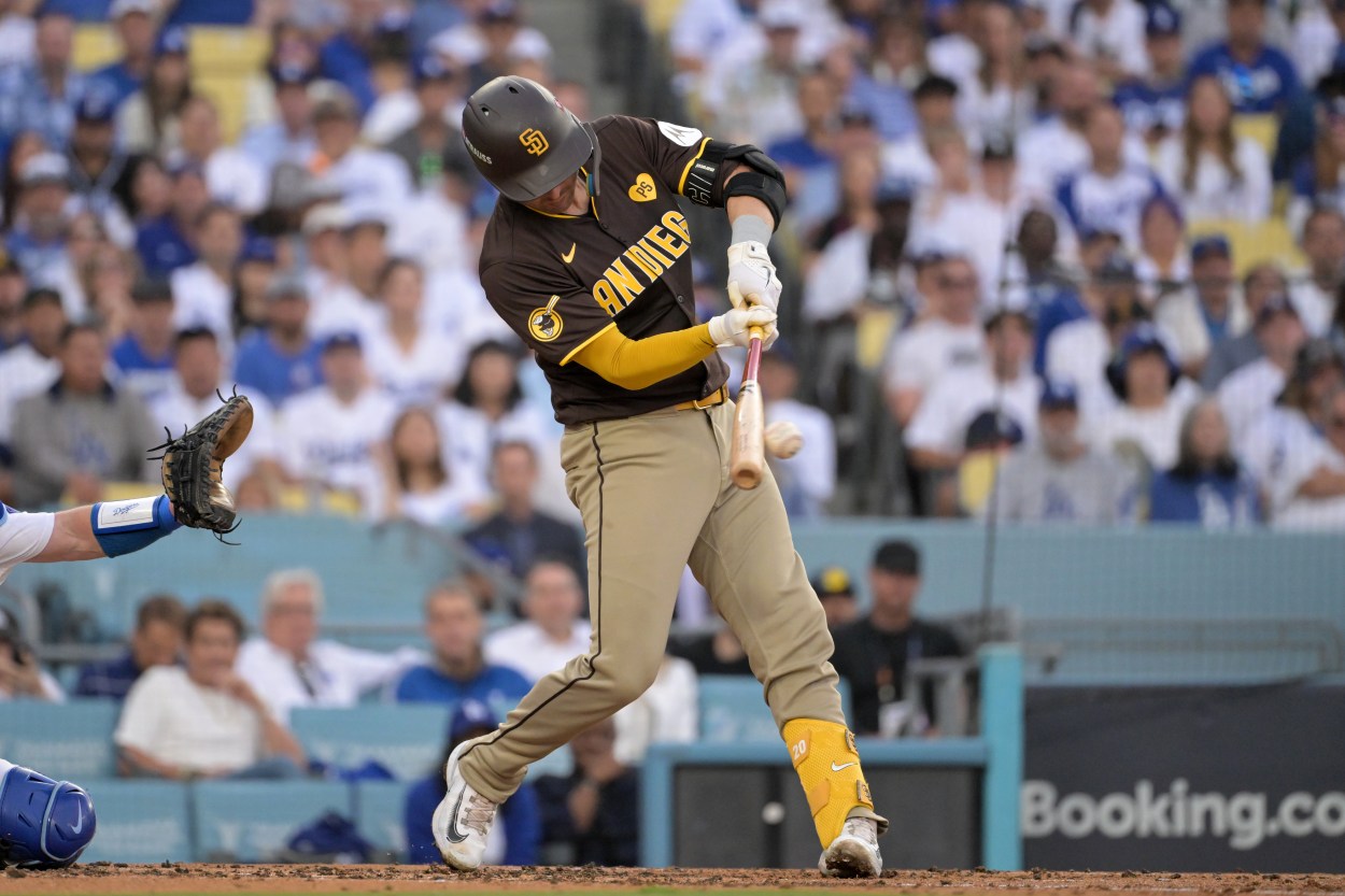 Oct 11, 2024; Los Angeles, California, USA; San Diego Padres catcher Kyle Higashioka (20) hits a single in the third inning against the Los Angeles Dodgers during game five of the NLDS for the 2024 MLB Playoffs at Dodger Stadium. Mandatory Credit: Jayne Kamin-Oncea-Imagn Images