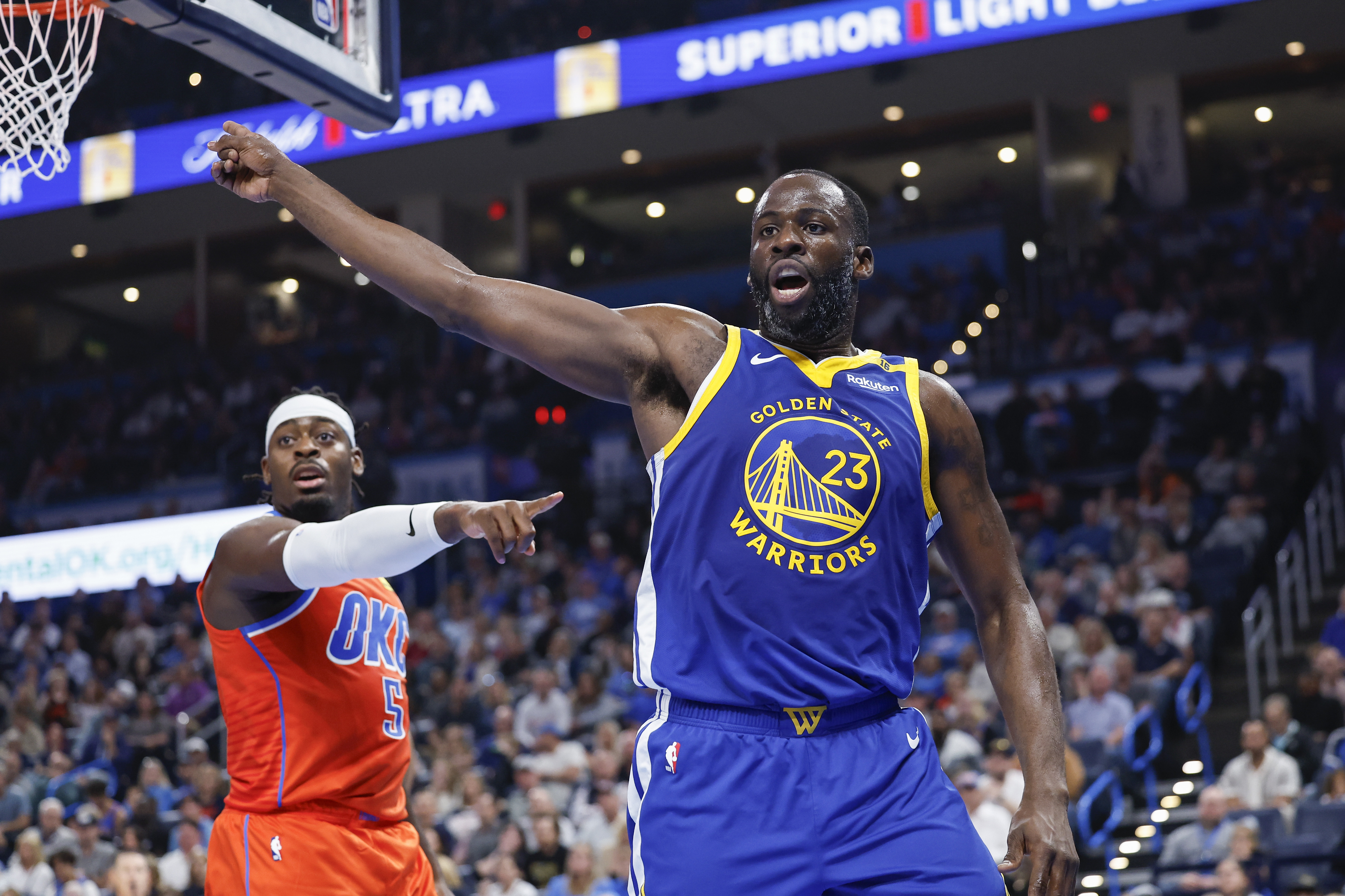 Nov 10, 2024; Oklahoma City, Oklahoma, USA; Golden State Warriors forward Draymond Green (23) and Oklahoma City Thunder guard Luguentz Dort (5) react after a play during the second quarter at Paycom Center. Mandatory Credit: Alonzo Adams-Imagn Images