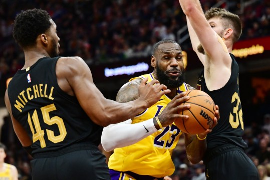 Oct 30, 2024; Cleveland, Ohio, USA; Los Angeles Lakers forward LeBron James (23) drives to the basket between Cleveland Cavaliers guard Donovan Mitchell (45) and forward Dean Wade (32) during the second half at Rocket Mortgage FieldHouse. Mandatory Credit: Ken Blaze-Imagn Images