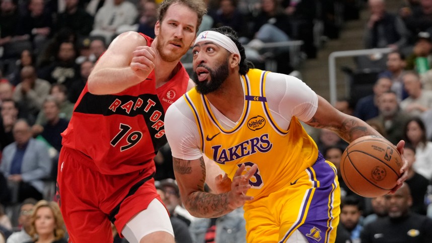 Nov 1, 2024; Toronto, Ontario, CAN; Los Angeles Lakers forward Anthony Davis (3) drives to the net past Toronto Raptors center Jakob Poeltl (19) during the first half at Scotiabank Arena. Mandatory Credit: John E. Sokolowski-Imagn Images