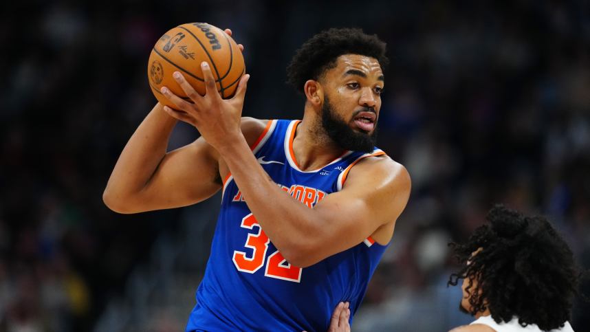 Nov 25, 2024; Denver, Colorado, USA; New York Knicks center Karl-Anthony Towns (32) controls the ball over Denver Nuggets guard Julian Strawther (3) in the second half at Ball Arena. Mandatory Credit: Ron Chenoy-Imagn Images