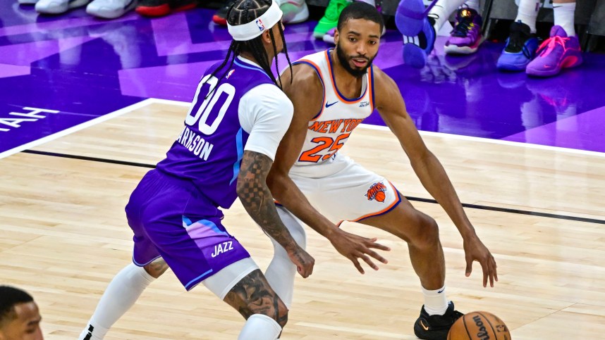 Nov 23, 2024; Salt Lake City, Utah, USA; New York Knicks guard/forward Mikal Bridges (25) dribbles the ball against Utah Jazz guard Jordan Clarkson (00) during the second half at the Delta Center. Mandatory Credit: Christopher Creveling-Imagn Images