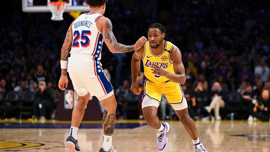 Nov 8, 2024; Los Angeles, California, USA; Los Angeles Lakers guard Bronny James (9) runs past Philadelphia 76ers guard Lester Quinones (25) during the second half at Crypto.com Arena. Mandatory Credit: Jonathan Hui-Imagn Images