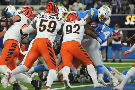 Nov 17, 2024; Inglewood, California, USA; Los Angeles Chargers running back J.K. Dobbins (27) scores on a 1-yard touchdown run against Cincinnati Bengals linebacker Akeem Davis-Gaither (59) and defensive tackle B.J. Hill (92) in the first half at SoFi Stadium. Mandatory Credit: Kirby Lee-Imagn Images