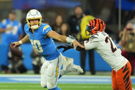 Nov 17, 2024; Inglewood, California, USA; Los Angeles Chargers quarterback Justin Herbert (10) is pressured by Cincinnati Bengals cornerback Josh Newton (28) in the second half at SoFi Stadium. Mandatory Credit: Kirby Lee-Imagn Images