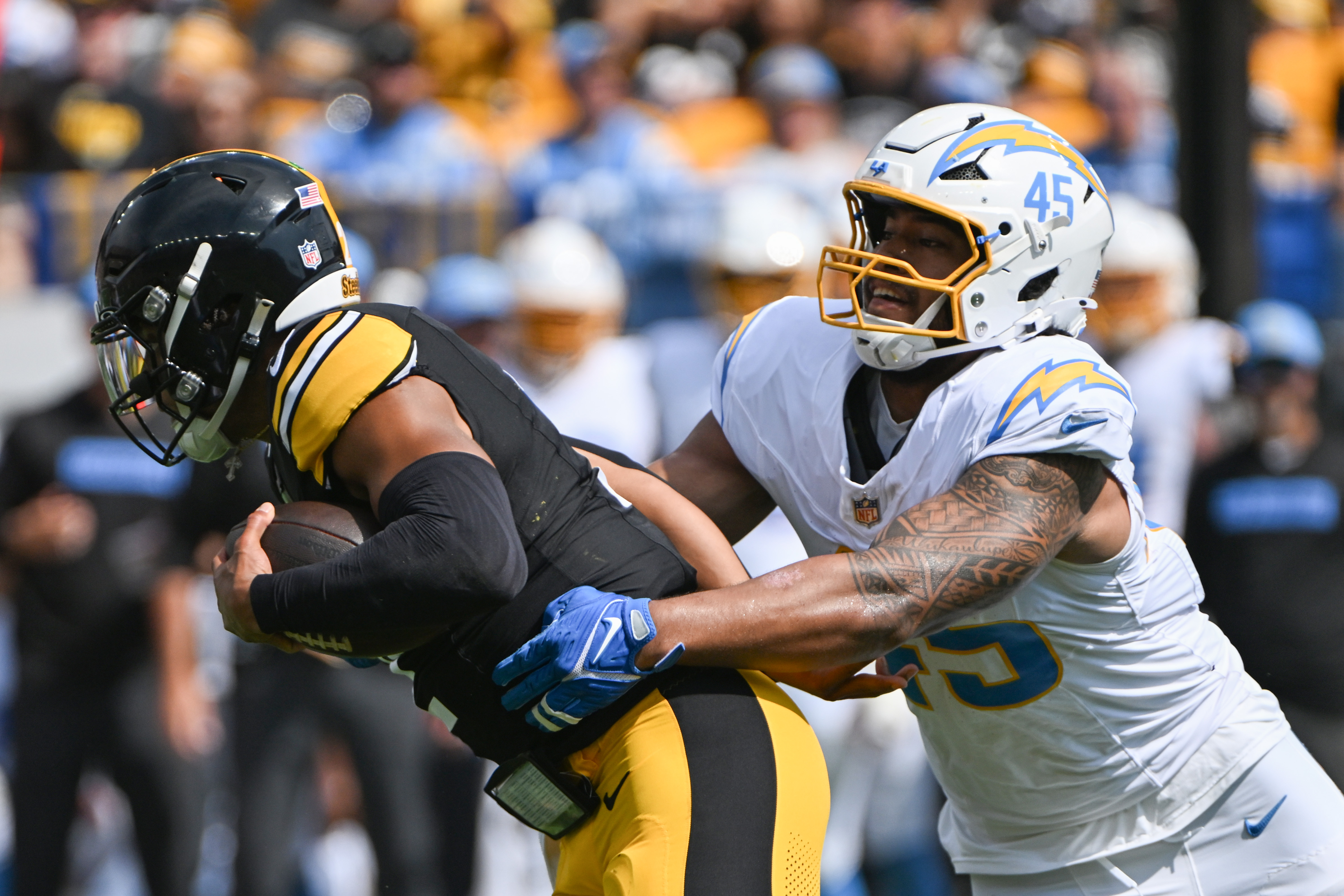 Sep 22, 2024; Pittsburgh, Pennsylvania, USA; Pittsburgh Steelers quarterback Justin Fields (2) is tackled by Los Angeles Chargers linebacker Tuli Tuipulotu (45) during the first quarter at Acrisure Stadium. Mandatory Credit: Barry Reeger-Imagn Images