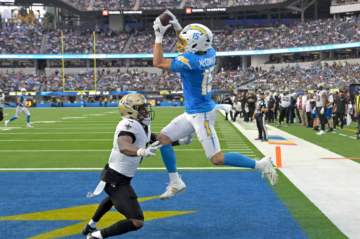 Oct 27, 2024; Inglewood, California, USA;  Los Angeles Chargers wide receiver Ladd McConkey (15) hangs on the the ball for a touchdown as he is defended by New Orleans Saints safety Ugo Amadi (0) in the second half at SoFi Stadium. Mandatory Credit: Jayne Kamin-Oncea-Imagn Images