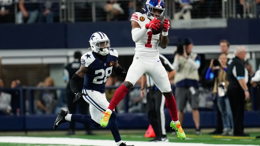 Nov 28, 2024; Arlington, Texas, USA;  New York Giants wide receiver Malik Nabers (1) catches a pass as Dallas Cowboys safety Malik Hooker (28) gives chase during the first half at AT&T Stadium. Mandatory Credit: Chris Jones-Imagn Images