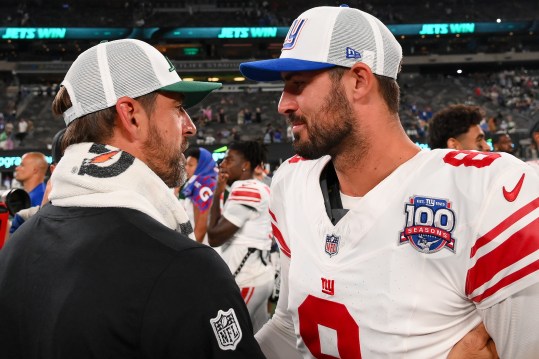 Aug 24, 2024; East Rutherford, New Jersey, USA; New York Jets quarterback Aaron Rodgers (left) and New York Giants quarterback Daniel Jones (right) meet following the game at MetLife Stadium. Mandatory Credit: Rich Barnes-Imagn Images