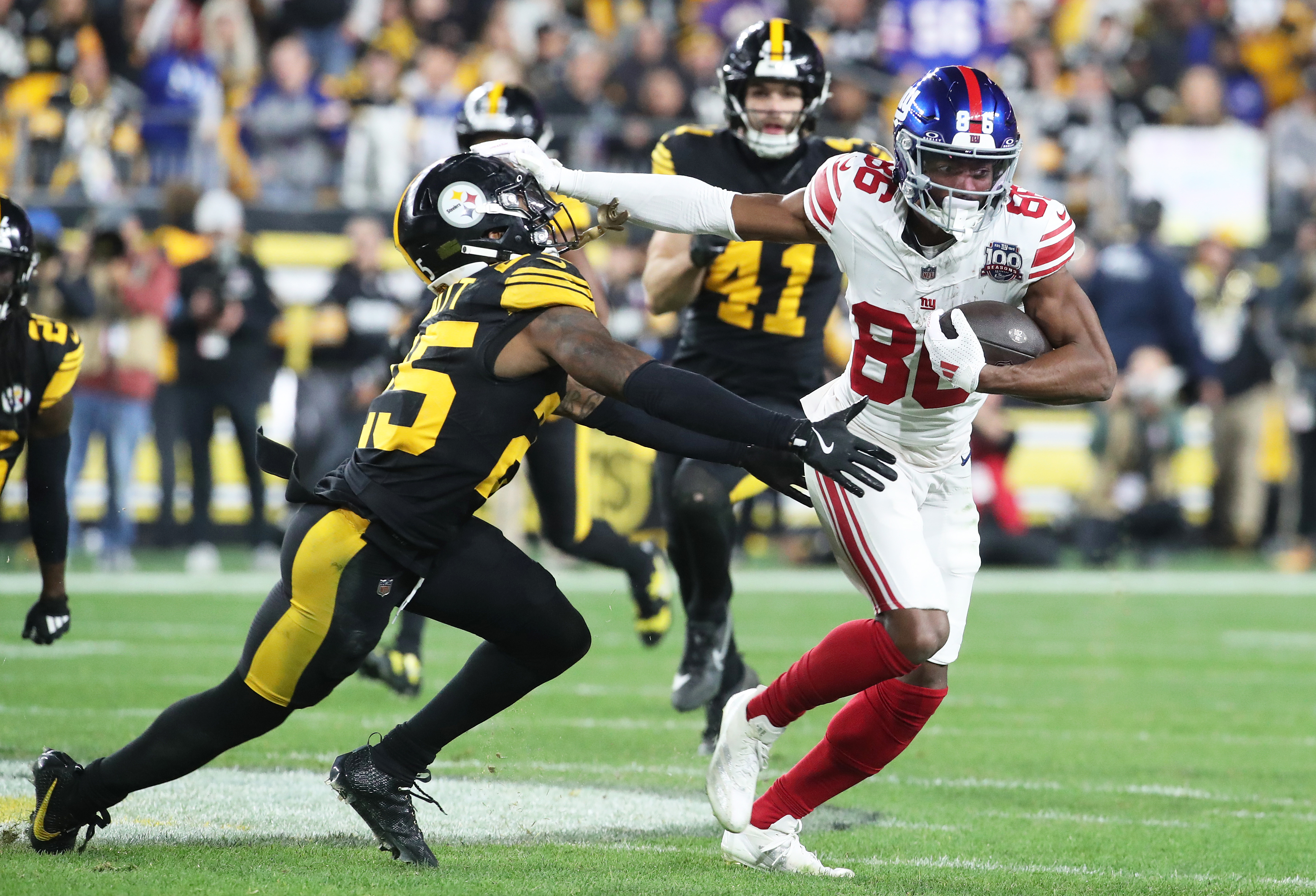 Oct 28, 2024; Pittsburgh, Pennsylvania, USA; New York Giants wide receiver Darius Slayton (86) runs after a catch as Pittsburgh Steelers safety DeShon Elliott (25) defends during the second quarter at Acrisure Stadium. Mandatory Credit: Charles LeClaire-Imagn Images