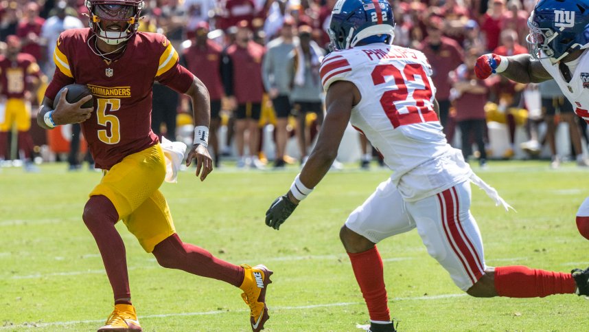 Sep 15, 2024; Landover, Maryland, USA; Washington Commanders quarterback Jayden Daniels (5) scrambles as New York Giants cornerback Dru Phillips (22) track him down during the first half at Commanders Field. Mandatory Credit: Luke Johnson-Imagn Images