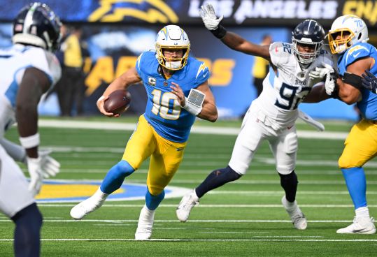 Nov 10, 2024; Inglewood, California, USA; Los Angeles Chargers quarterback Justin Herbert (10) scramble out of the pocket during the first quarter against the Tennessee Titans at SoFi Stadium. Mandatory Credit: Robert Hanashiro-Imagn Images