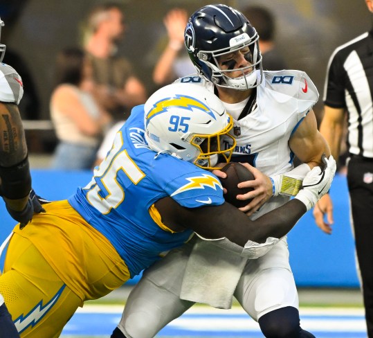 Nov 10, 2024; Inglewood, California, USA; Los Angeles Chargers defensive tackle Poona Ford (95) sacks Tennessee Titans quarterback Will Levis (8) during the second quarter at SoFi Stadium. Mandatory Credit: Robert Hanashiro-Imagn Images