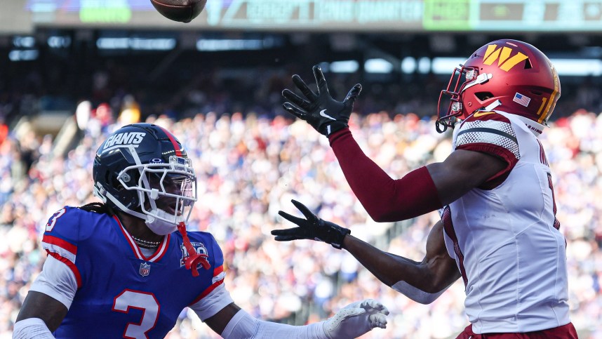 Nov 3, 2024; East Rutherford, New Jersey, USA; Washington Commanders wide receiver Terry McLaurin (17) catches a touchdown pass as New York Giants cornerback Deonte Banks (3) defends during the first half at MetLife Stadium. Mandatory Credit: Vincent Carchietta-Imagn Images