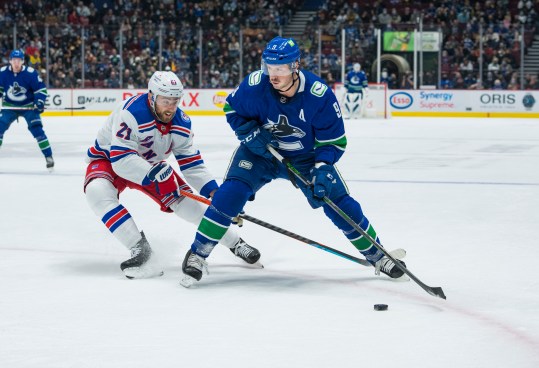 Nov 2, 2021; Vancouver, British Columbia, CAN; New York Rangers  forward Barclay Goodrow (21) checks Vancouver Canucks forward J.T. Miller (9) in the first period at Rogers Arena. Mandatory Credit: Bob Frid-Imagn Images