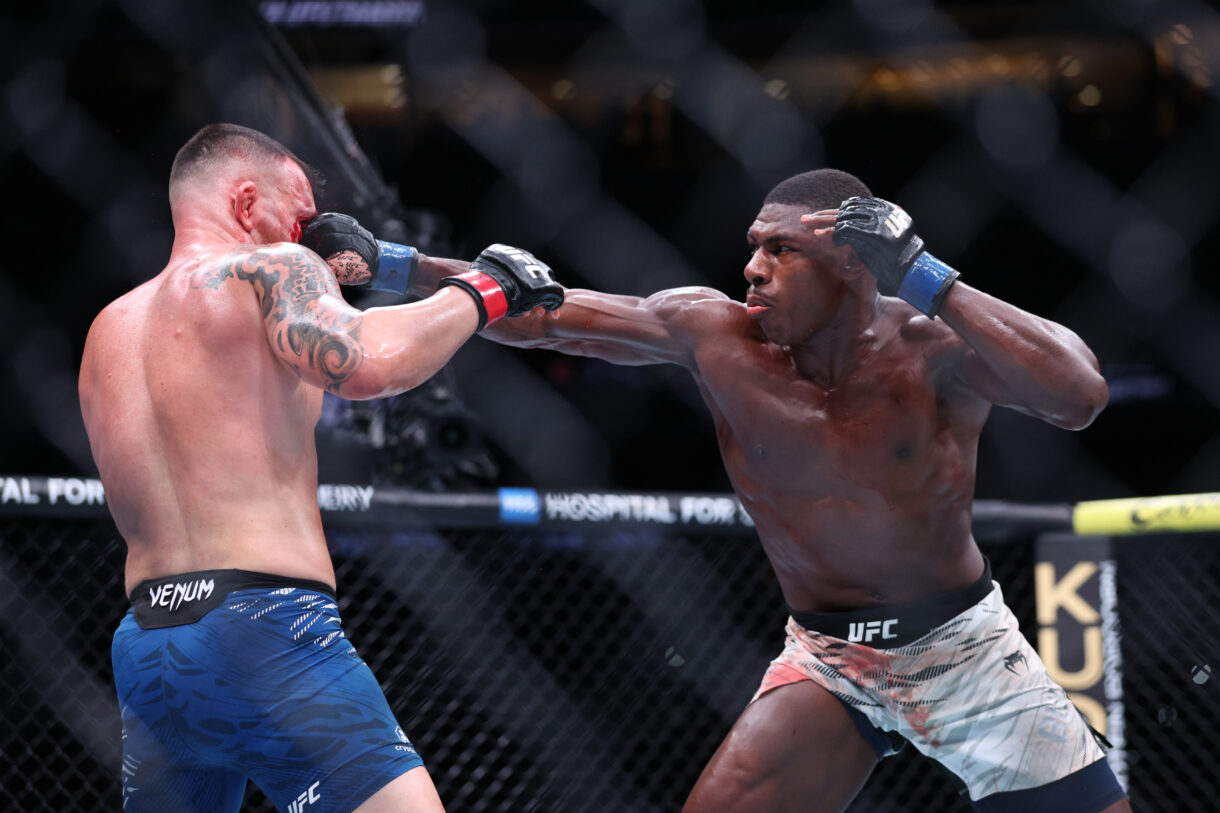 Dec 14, 2024; Tampa, Florida, UNITED STATES;  Colby Covington (red gloves) fights Joaquin Buckley (blue gloves) at Amalie Arena. Mandatory Credit: Nathan Ray Seebeck-Imagn Images