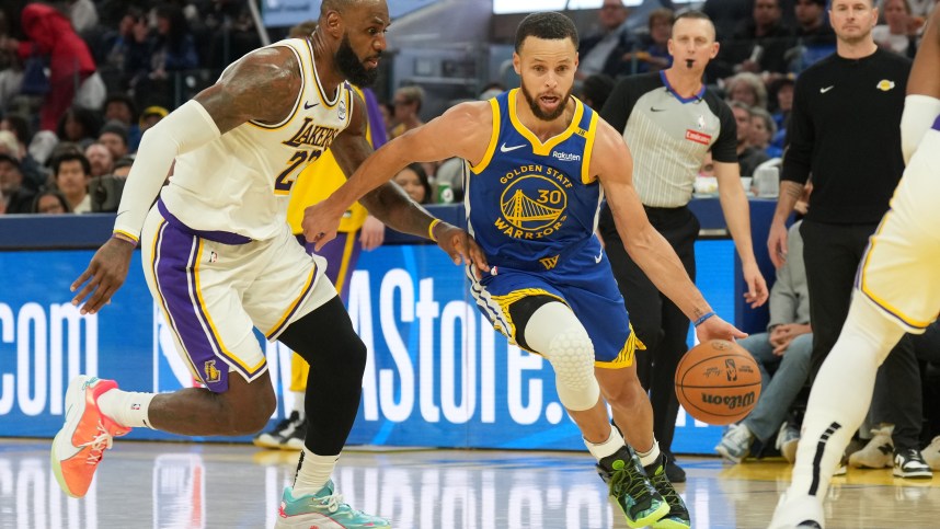 Dec 25, 2024; San Francisco, California, USA; Golden State Warriors guard Stephen Curry (30) dribbles against Los Angeles Lakers forward LeBron James (left) during the third quarter at Chase Center. Mandatory Credit: Darren Yamashita-Imagn Images