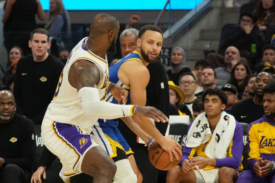 Dec 25, 2024; San Francisco, California, USA; Golden State Warriors guard Stephen Curry (center right) handles the ball against Los Angeles Lakers forward LeBron James (center left) during the fourth quarter at Chase Center. Mandatory Credit: Darren Yamashita-Imagn Images