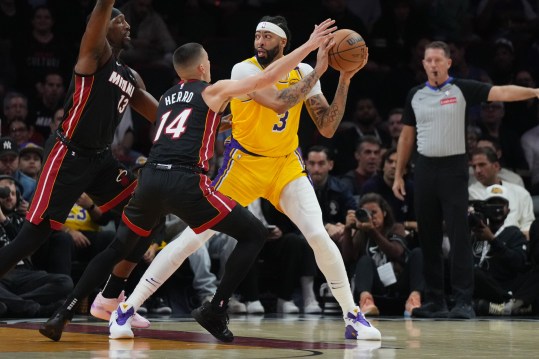 Dec 4, 2024; Miami, Florida, USA;  Los Angeles Lakers forward Anthony Davis (3) looks to pass against Miami Heat guard Tyler Herro (14) during the first half at Kaseya Center. Mandatory Credit: Jim Rassol-Imagn Images