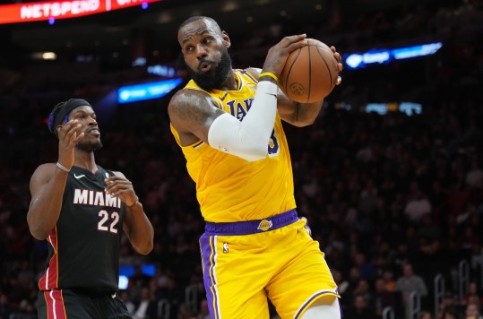 Dec 4, 2024; Miami, Florida, USA; Los Angeles Lakers forward LeBron James (23) grabs a rebound in front of Miami Heat forward Jimmy Butler (22) in the first half at Kaseya Center. Mandatory Credit: Jim Rassol-Imagn Images