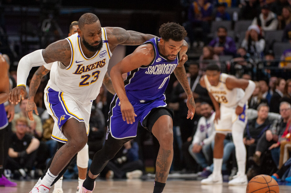Dec 21, 2024; Sacramento, California, USA; Los Angeles Lakers forward LeBron James (23) and Sacramento Kings guard Malik Monk (0) fight for possession of the ball during the fourth quarter at Golden 1 Center. Mandatory Credit: Ed Szczepanski-Imagn Images