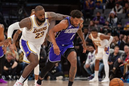 Dec 21, 2024; Sacramento, California, USA; Los Angeles Lakers forward LeBron James (23) and Sacramento Kings guard Malik Monk (0) fight for possession of the ball during the fourth quarter at Golden 1 Center. Mandatory Credit: Ed Szczepanski-Imagn Images