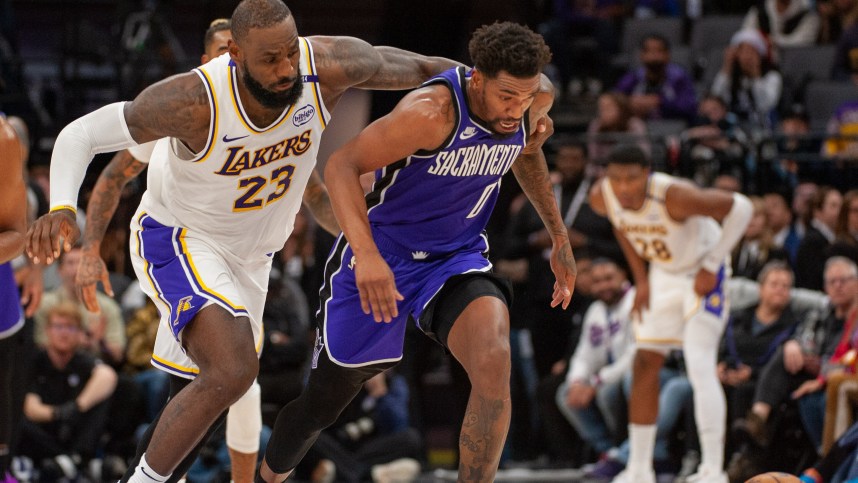 Dec 21, 2024; Sacramento, California, USA; Los Angeles Lakers forward LeBron James (23) and Sacramento Kings guard Malik Monk (0) fight for possession of the ball during the fourth quarter at Golden 1 Center. Mandatory Credit: Ed Szczepanski-Imagn Images