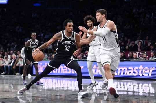 Dec 8, 2024; Brooklyn, New York, USA; Brooklyn Nets center Nic Claxton (33) drives to the basket while being defended by Milwaukee Bucks center Brook Lopez (11) during the first half at Barclays Center. Mandatory Credit: John Jones-Imagn Images