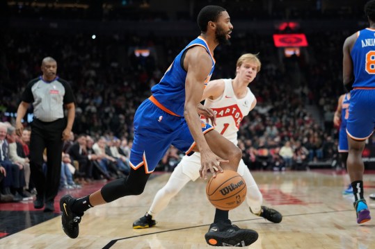 Dec 9, 2024; Toronto, Ontario, CAN; New York Knicks forward Mikal Bridges (25) drives past Toronto Raptors guard Gradey Dick (1) during the first half at Scotiabank Arena. Mandatory Credit: John E. Sokolowski-Imagn Images